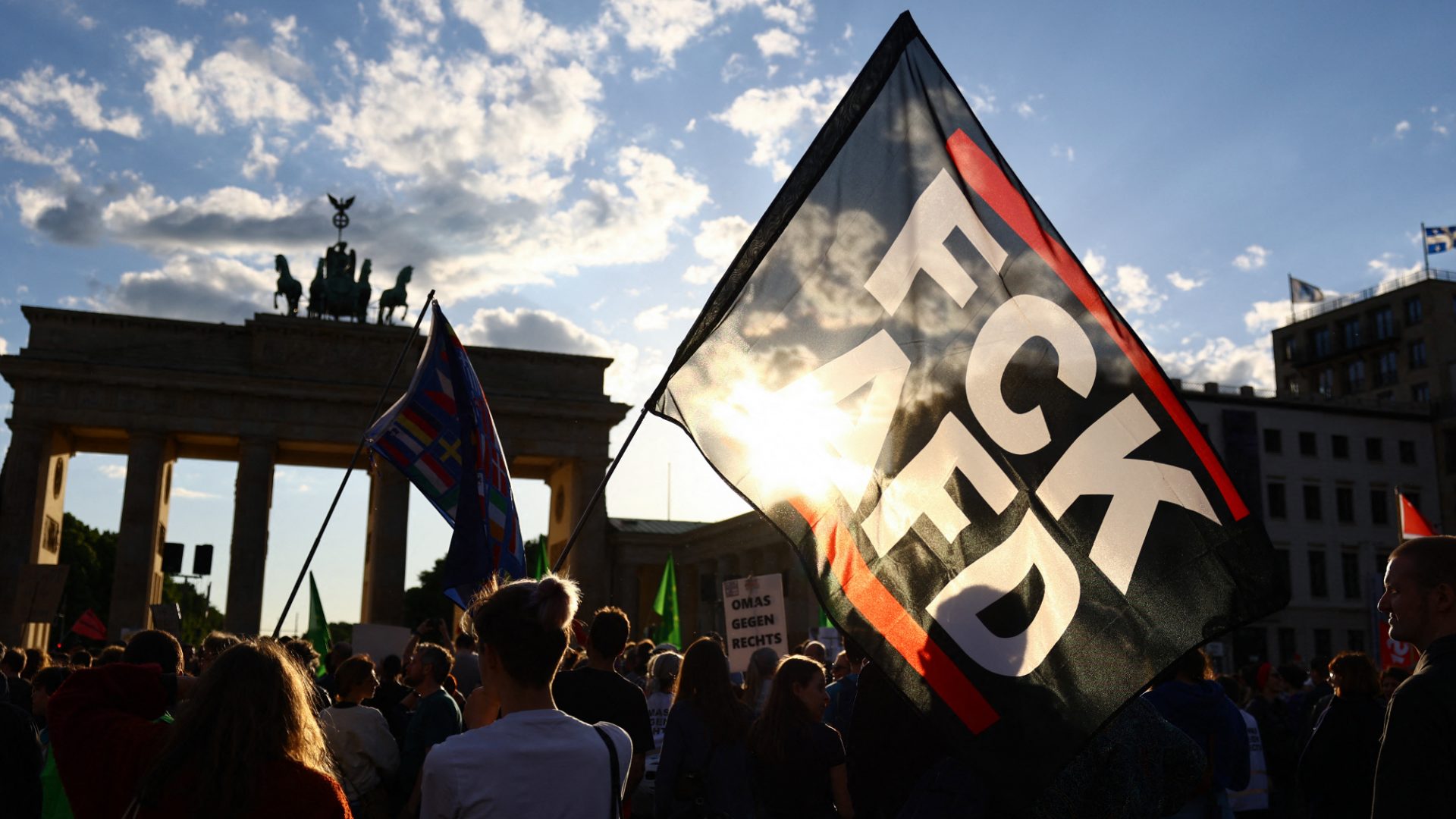 A participant holds a flag with the slogan ‘Fck AfD’ during a demonstration against the far right in front of the Brandenburg Gate in Berlin, May 2024. Photo: Christian Mang/AFP/Getty