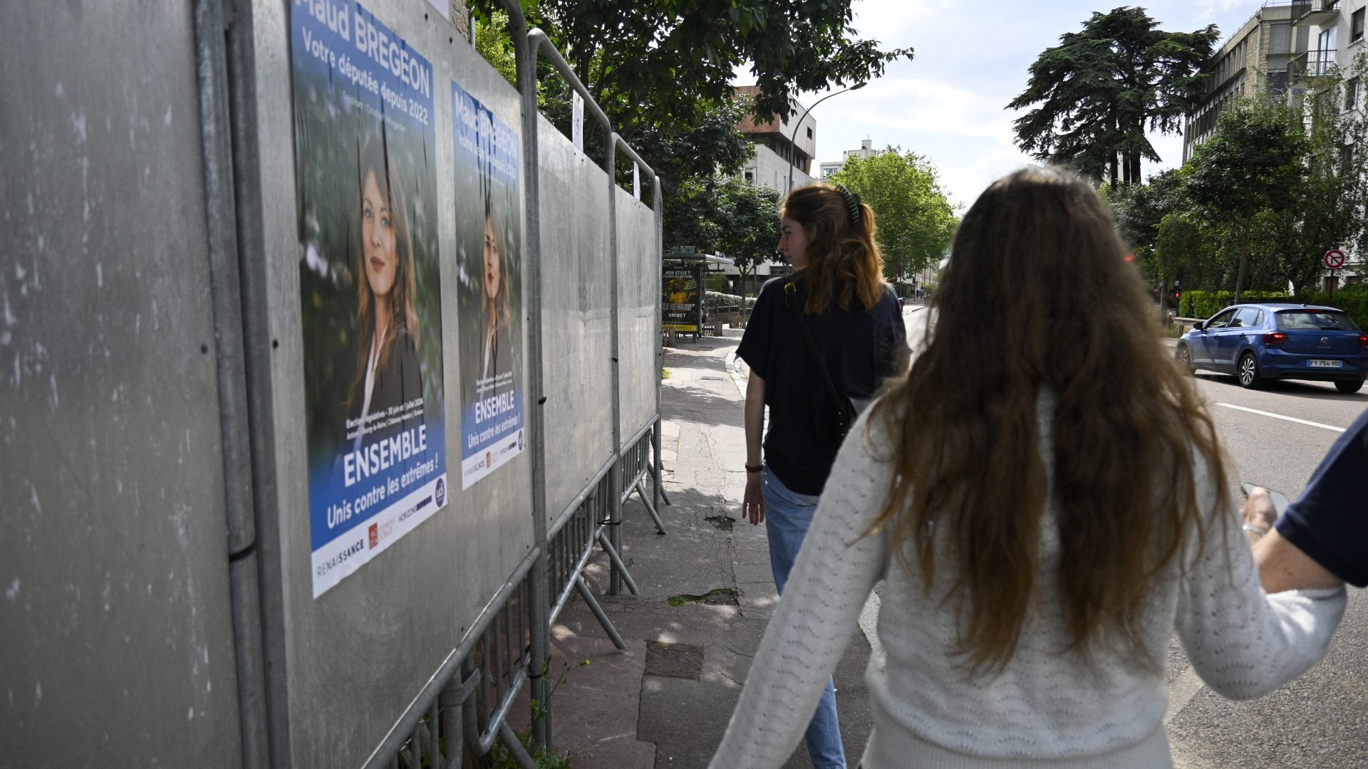 A woman looks at the poster of Ensemble candidate Maud Bregeon in Sceaux (Photo by MAGALI COHEN/Hans Lucas/AFP via Getty Images)