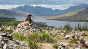 A cairn sits on top of a hill by the A87 from Invergarry to the Isle of Skye, with Loch Loyne in the background. Cairn is the new book by Kathleen Jamie, right, the makar, or national poet laureate, for Scotland. Photo: Robert Pool/AFP/Getty