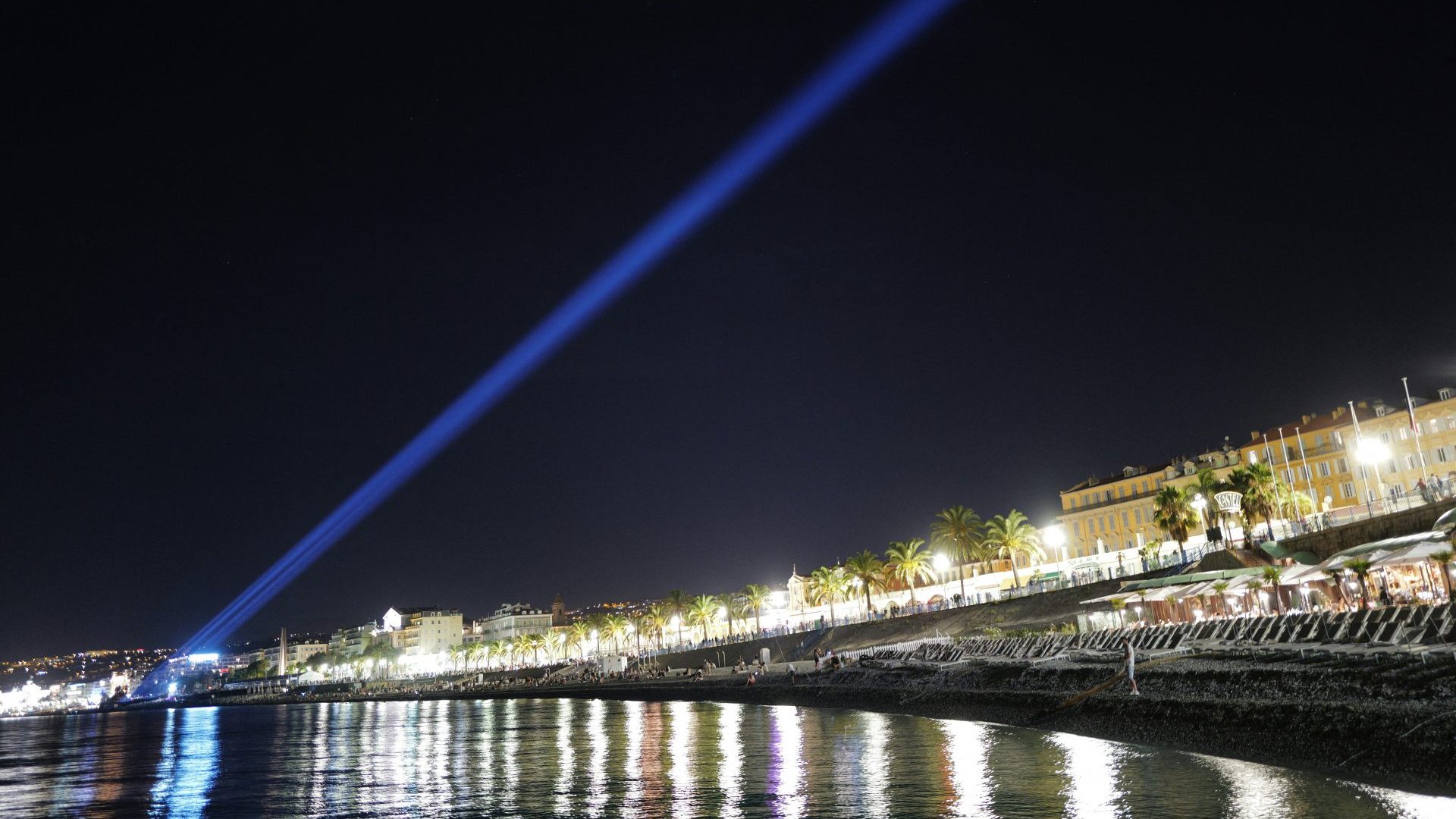 laser lights beams above the bay of Nice, southern France, during a commemorative ceremony marking the anniversary of the 2016 Bastille Day terrorist truck attack. Photo: VALERY HACHE/AFP via Getty Images
