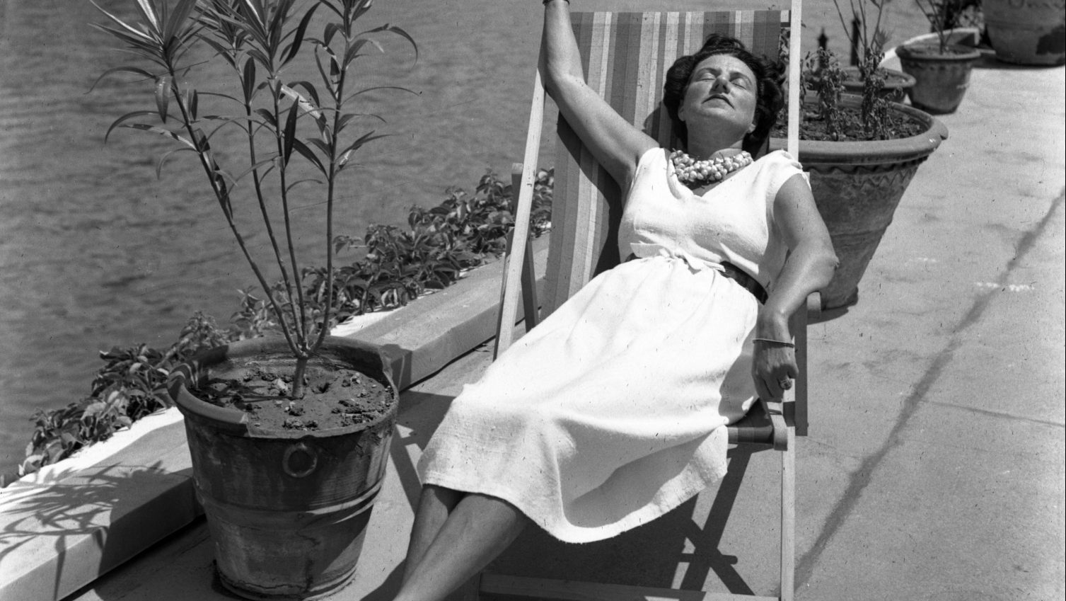 Peggy Guggenheim on the roof terrace of Palazzo Venier dei Leoni early 1950s; far left, Yew Tree Cottage in 2016 and, below, wearing earrings designed for her by Yves Tanguy. Photo: Guggenheim Foundation/Photo Archivio Cameraphoto Epoche/Calder Foundation