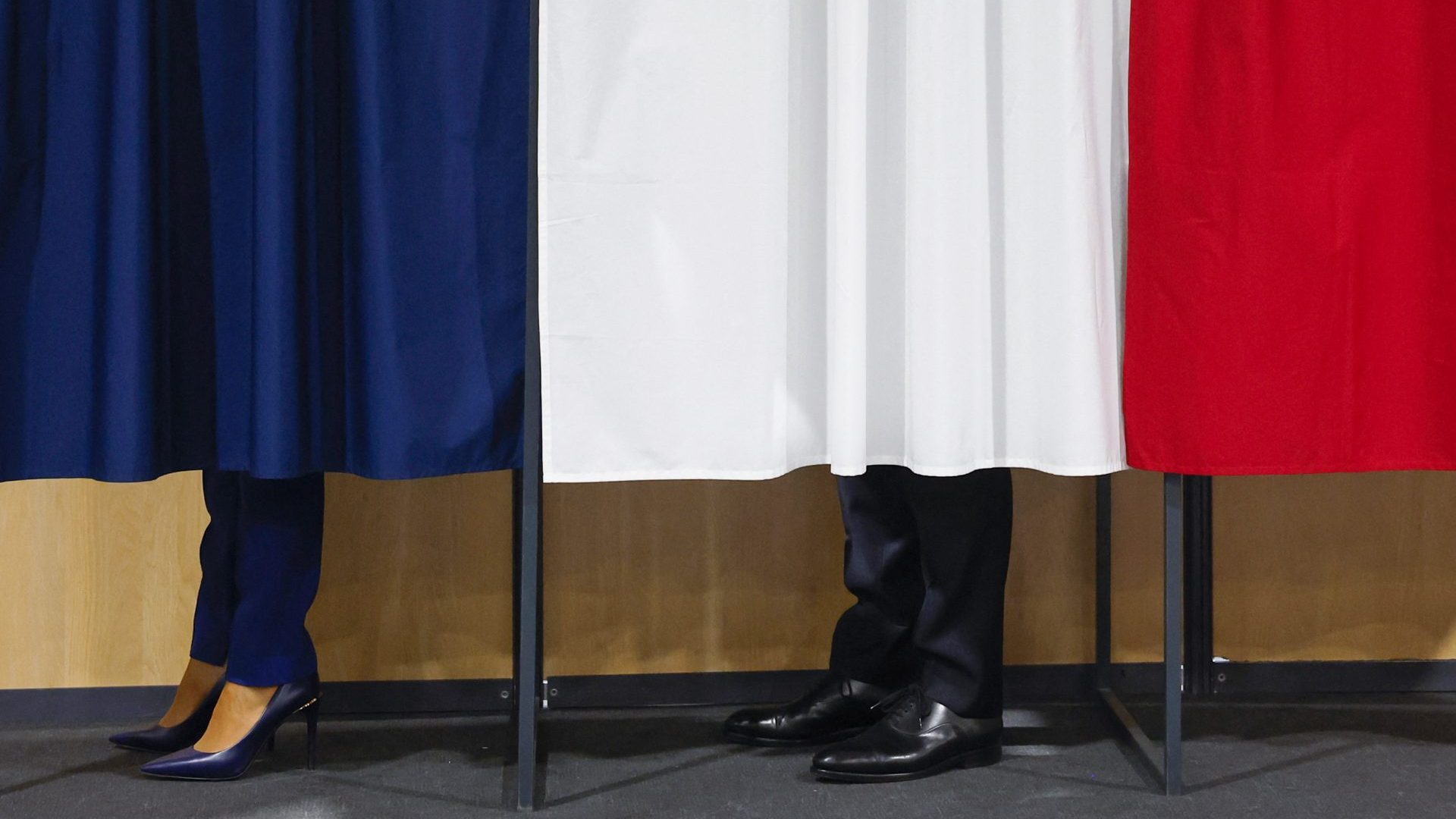 Emmanuel Macron, flanked by his wife Brigitte, votes in the second round of France's legislative election (Photo by MOHAMMED BADRA/POOL/AFP via Getty Images)