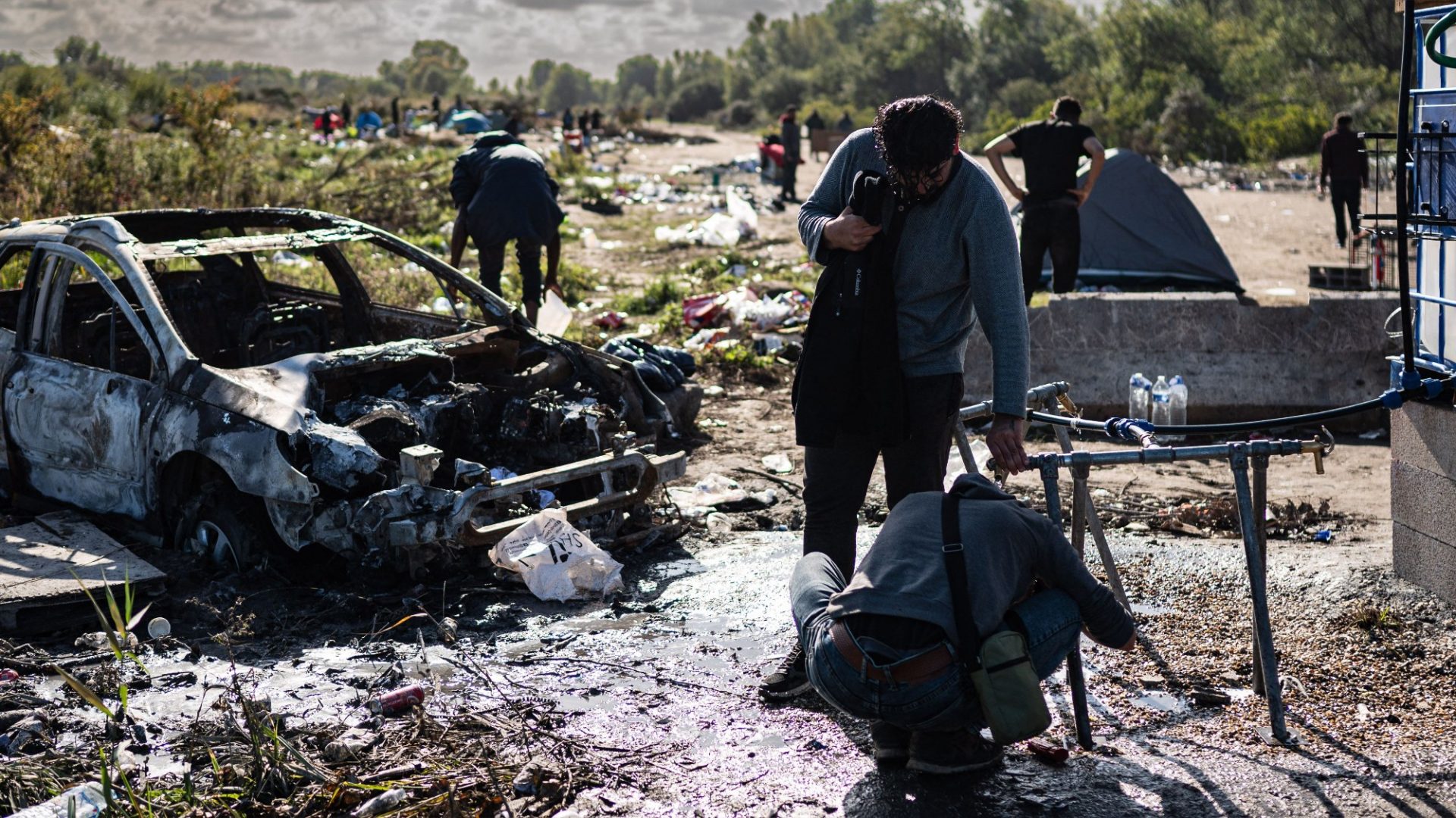 Iraqi-Kurd migrants wash themselves at a makeshift camp near Grande-Synthe, northern France. Photo: Sameer Al-Doumy/AFP/Getty