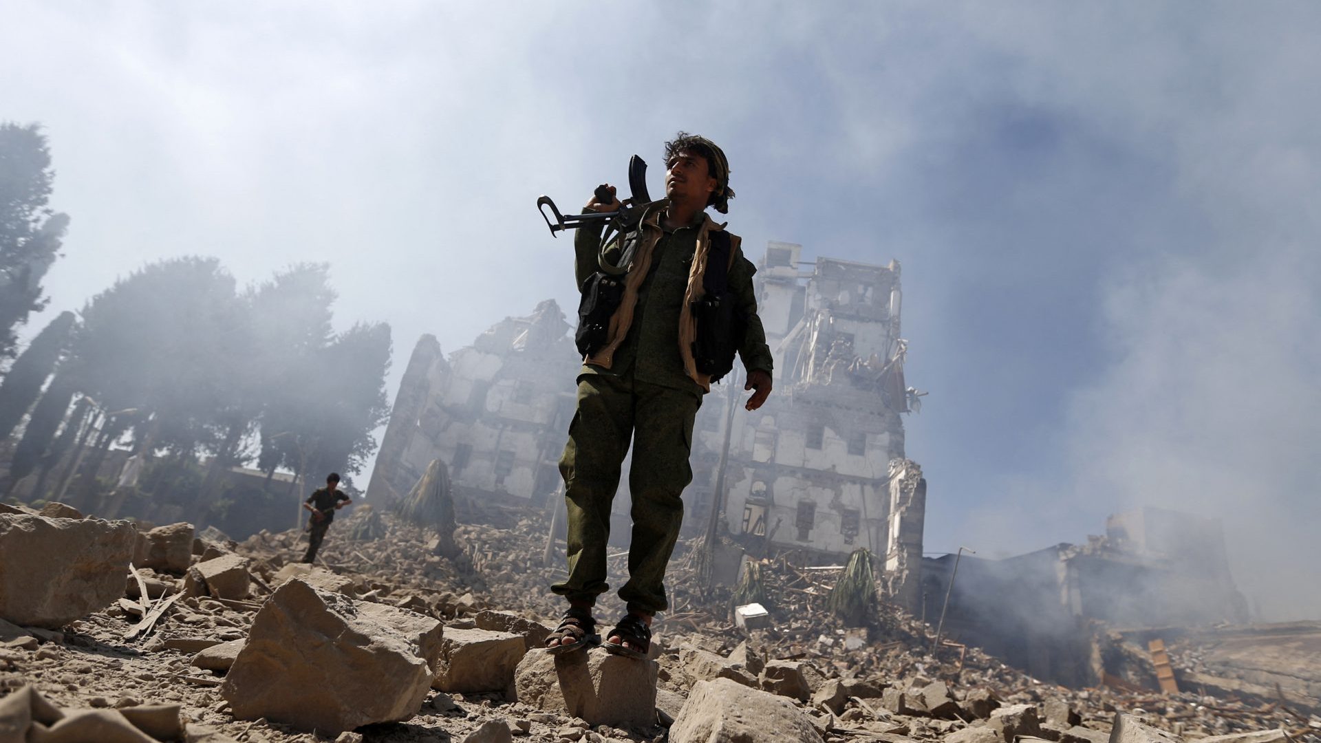 Huthi rebel fighters inspect the damage after a reported air strike carried out by the Saudi-led coalition targeted the presidential palace in the Yemeni capital Sanaa, December 2017. Photo: Mohammed Huwais/AFP/Getty