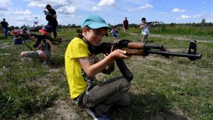 Russian children handle weapons that have been disengaged for safety as they play in the family historical tank park in St Petersburg. Photo: Olga Maltseva/AFP/Getty