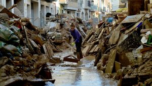 A woman works to clean mud and debris from a street in Paiporta, south of Valencia, in the aftermath of the worst floods in a generation. Photo: Jose Jordan/AFP/Getty