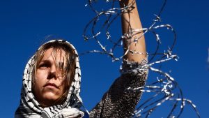 A woman protests against the Polish government’s plans to suspend the right to asylum for refugees crossing the border from Belarus. Photo: Beata Zawrzel/NurPhoto/Getty