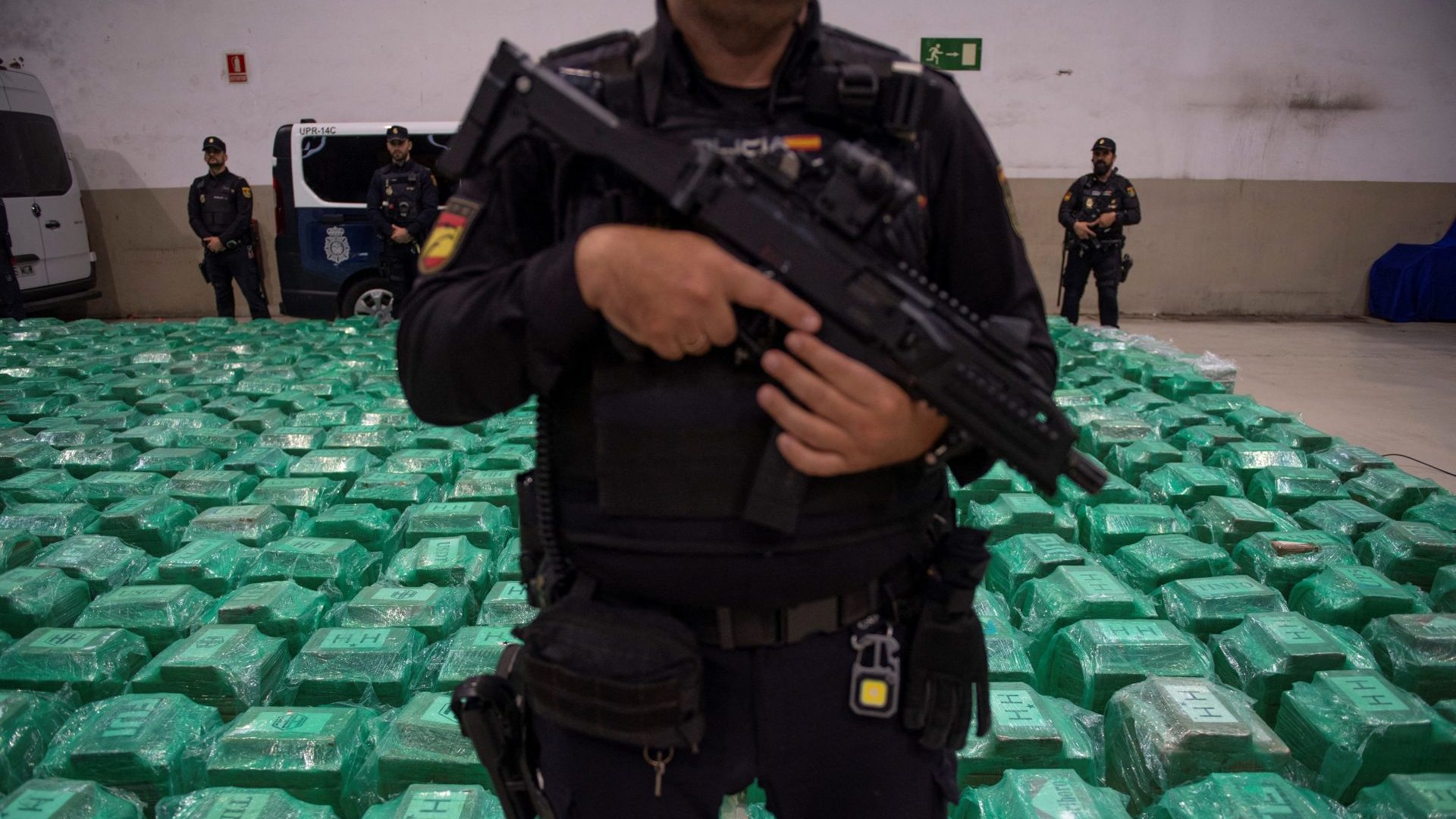 Spanish National Police and Customs officers stand next to packages of cocaine that were found in a container from Ecuador. Photo: JORGE GUERRERO/AFP via Getty Images