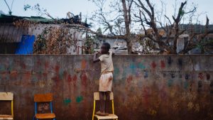 A boy looks over a wall in the village of Bouyouni on the French Indian Ocean territory of Mayotte following cyclone Chido’s devastating passage over the islands last month. Photo: Dimitar Dilkoff/AFP/Getty