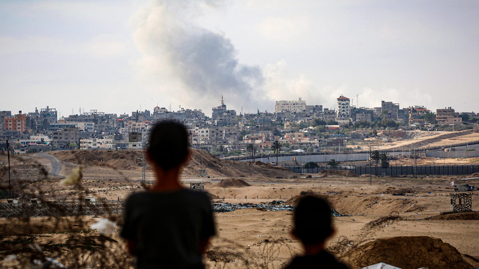 Children watch as smoke billows from Israeli airstrikes east of Rafah in southern Gaza amid the conflict between Israel and Hamas, May 2024. Photo: AFP/Getty
