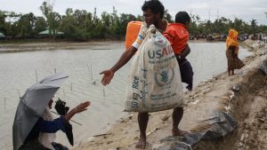 A Rohingya refugee carrying a USAID bag reaches out to a woman in Bangladesh as they flee violence in neighbouring Myanmar. Donald Trump has recently announced a 90-day freeze on funding for foreign aid projects. 
Photo: Emrul Kamal/AFP/Getty