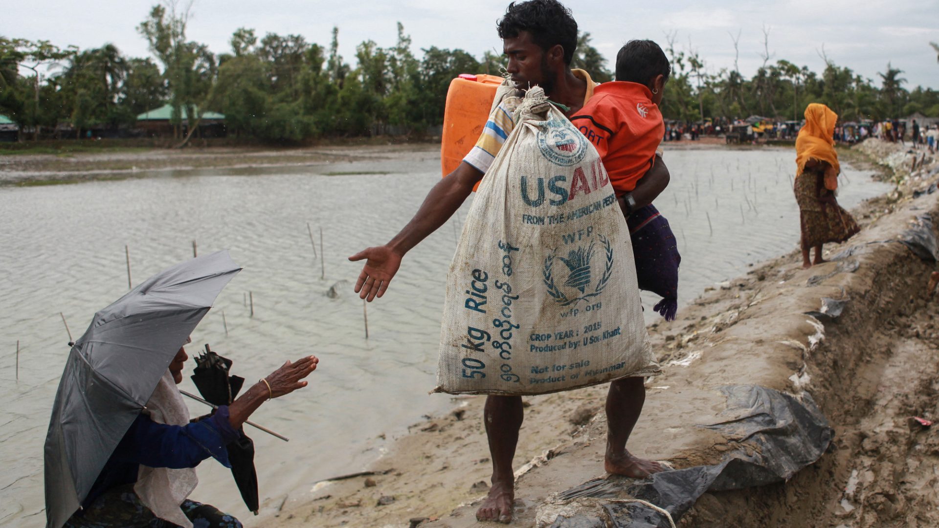 A Rohingya refugee carrying a USAID bag reaches out to a woman in Bangladesh as they flee violence in neighbouring Myanmar. Donald Trump has recently announced a 90-day freeze on funding for foreign aid projects. 
Photo: Emrul Kamal/AFP/Getty