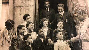 Christian philanthropist and community activist Daniels Ekarte (right of image) with a group of Black and mixed-race children in the city. Photo: Sam Wetherell